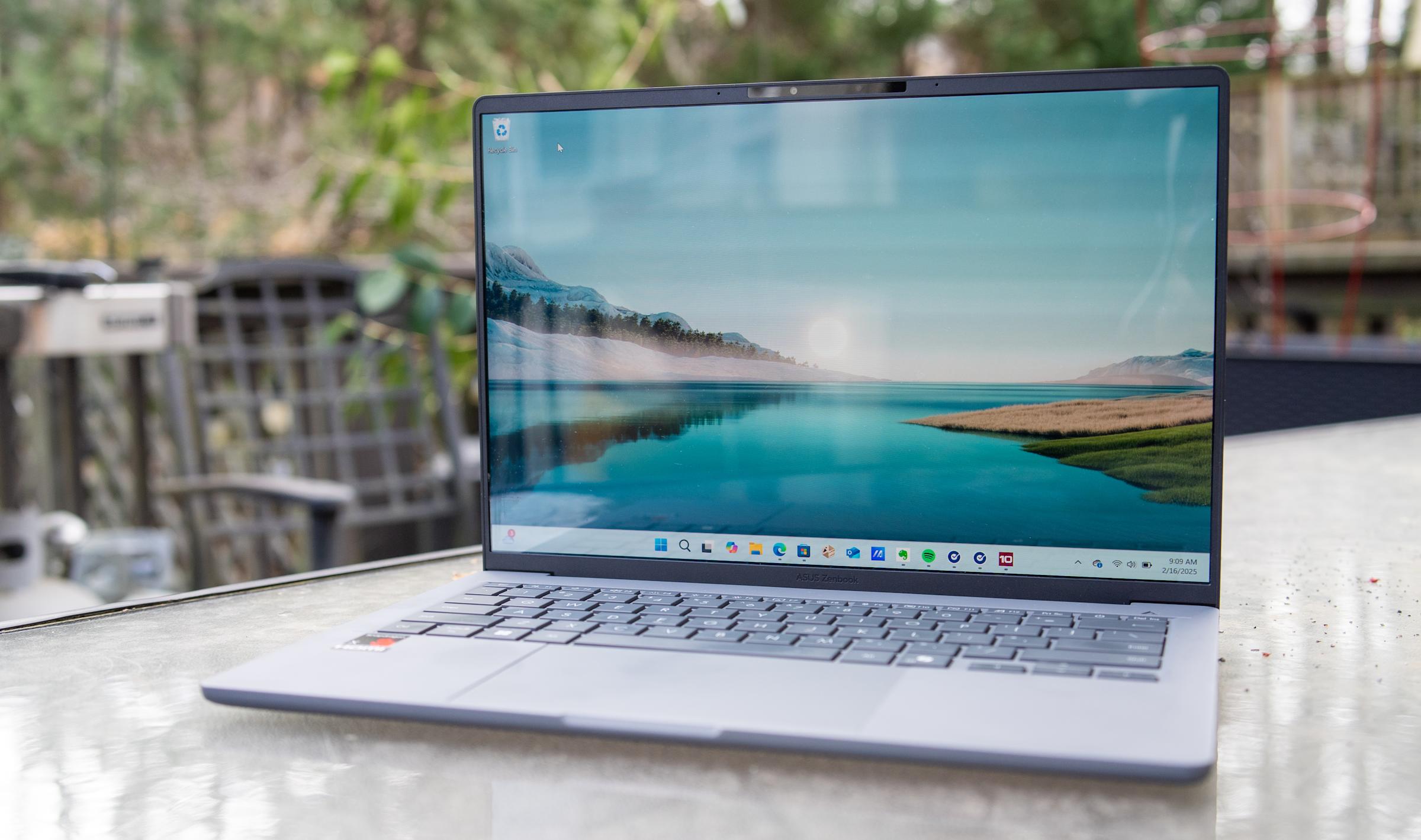 An Asus Zenbook A14 sits out a patio table. 