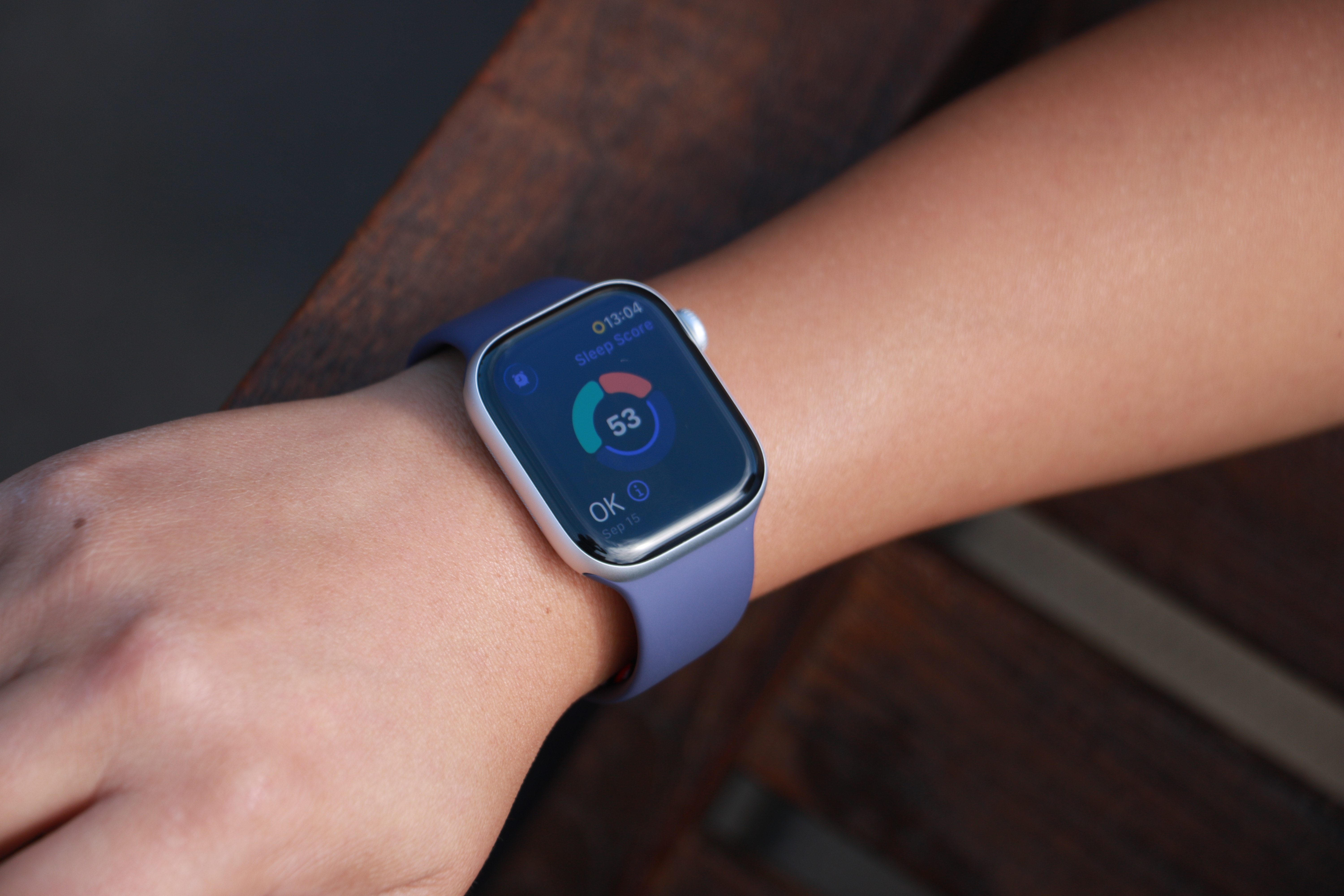 The Apple Watch Series 11 on a person's wrist, showing a ring with three segmented arcs encircling a Sleep Score of 53 and the description 