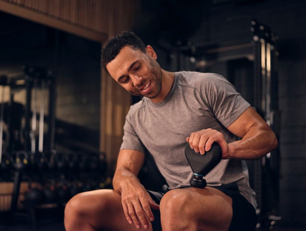A guy using the massager at the gym.