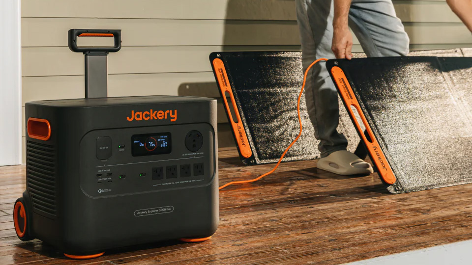 A person sets up the Jackery Solar Generator 3000 Pro on a porch outside