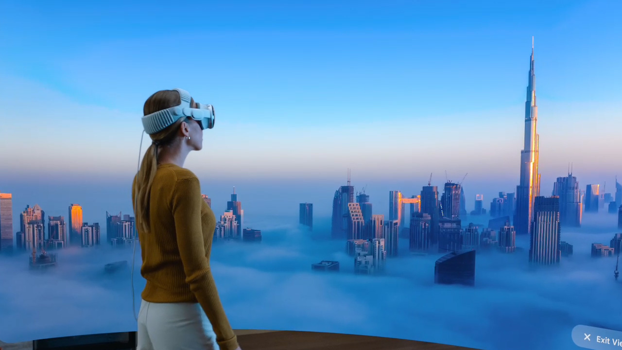 A person wearing Apple's Vision Pro headset looks at a virtual panorama of a city in clouds.