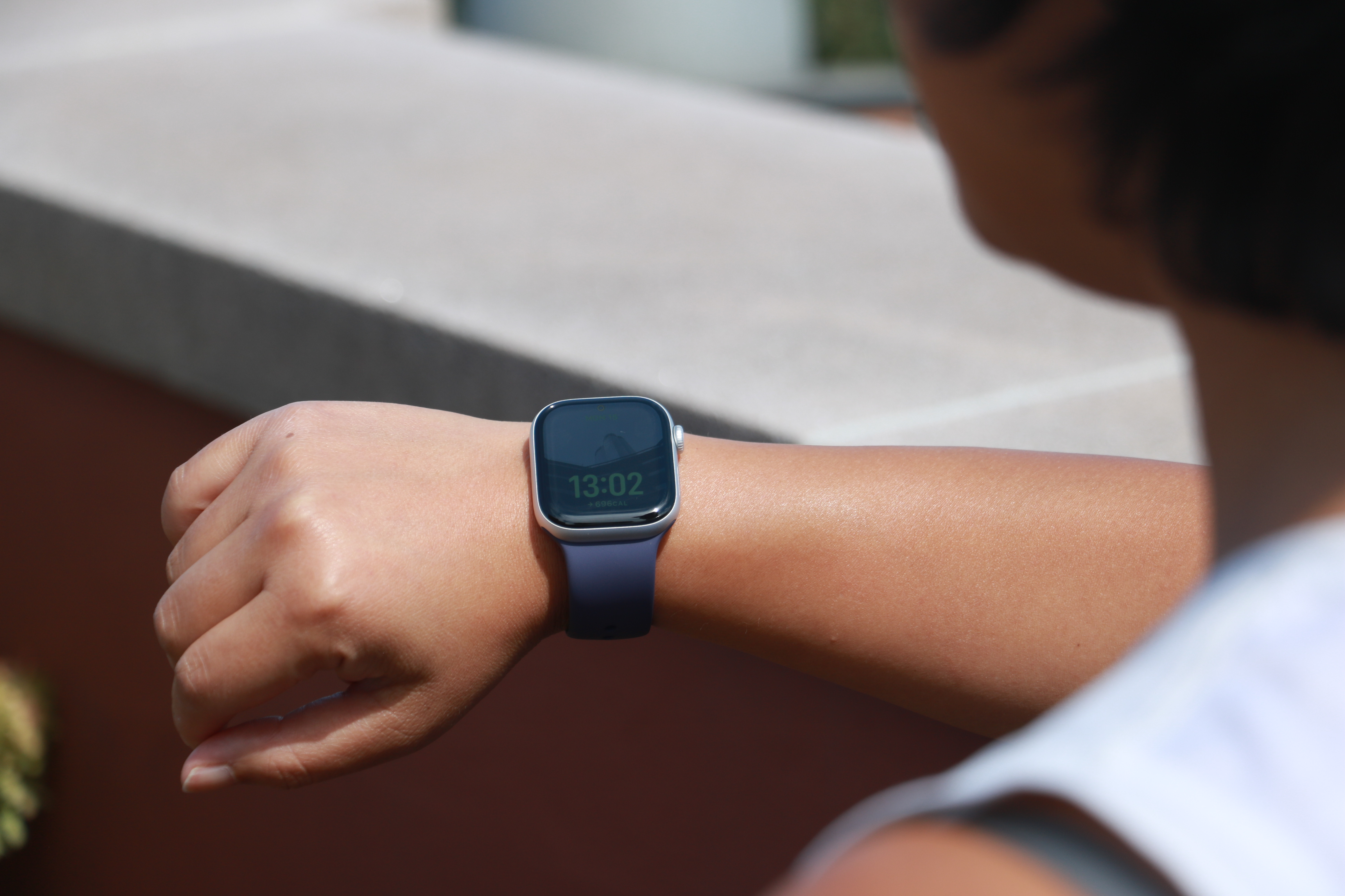 The Apple Watch Series 11 on a person's wrist, lifted slightly in mid-air.