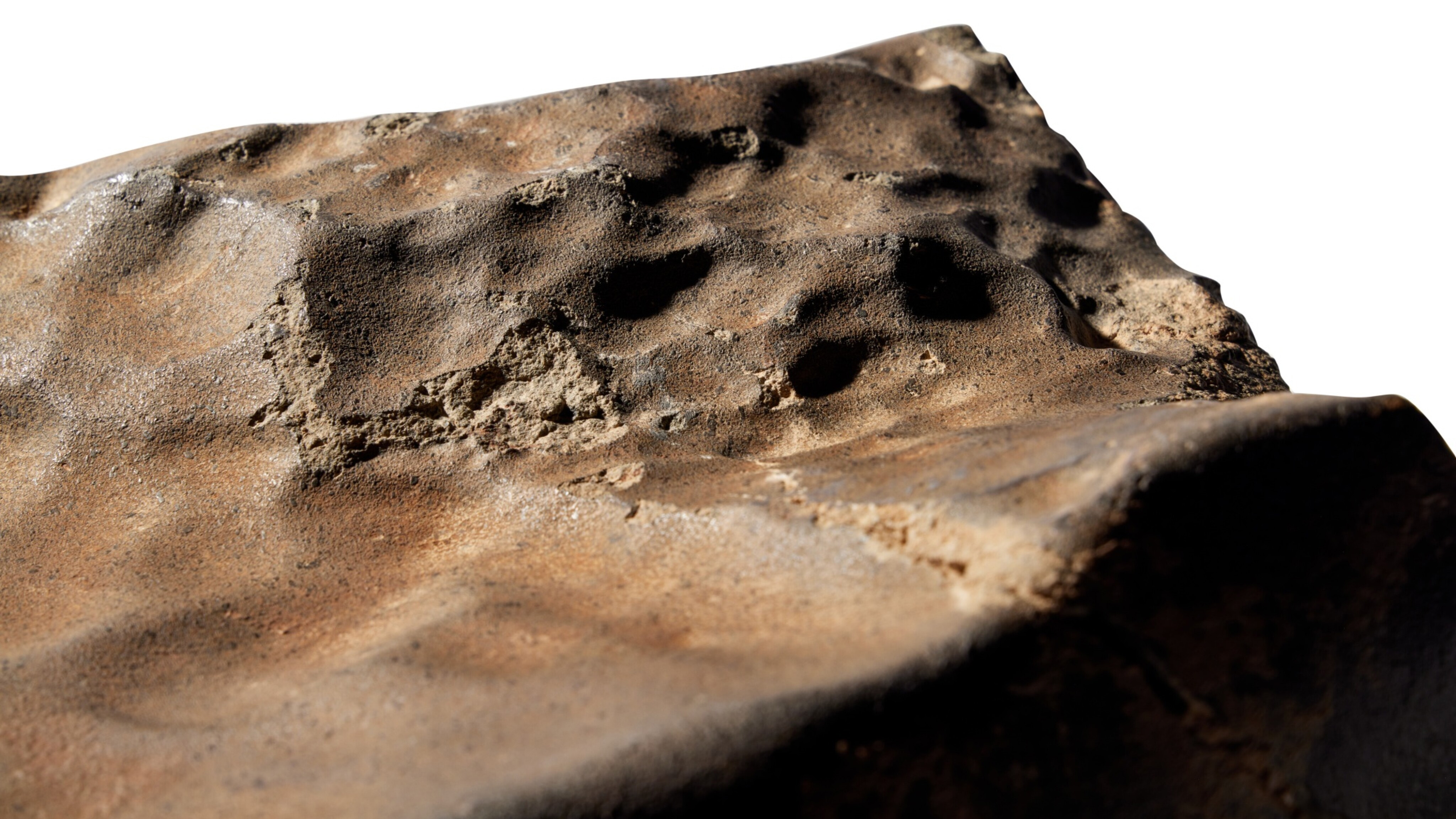 Closeup of a Mars meteorite. Reddish-brown, rocky surface.