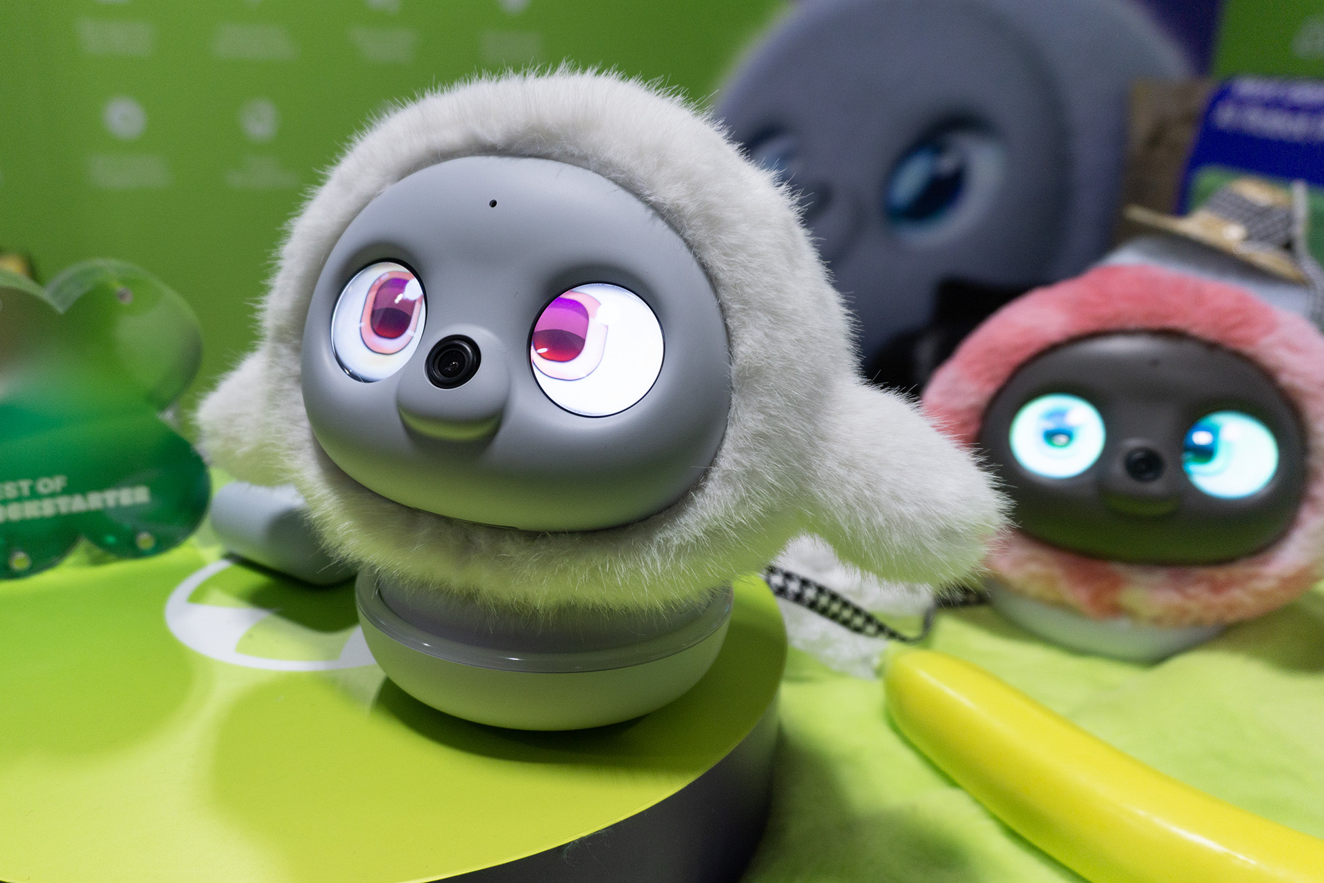 A gray Ropet device on a green table, with a pink Ropet seen in the background