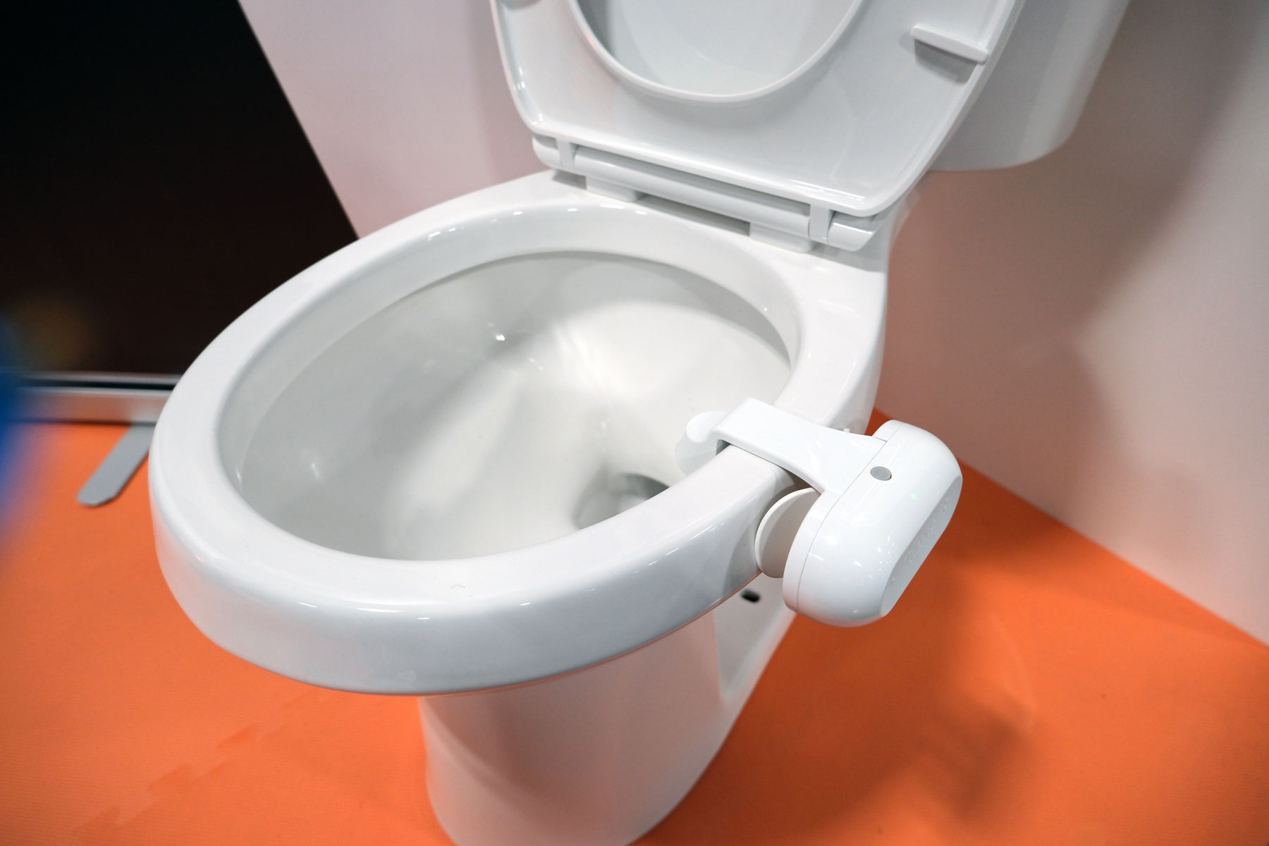 Image of the Throne Toilet Computer perched on the side of a toilet.