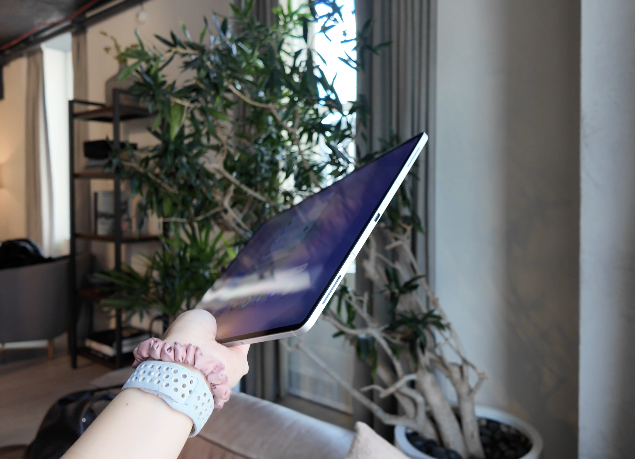 Side view of the Samsung Galaxy Tab S11 Ultra held in mid-air, showing its bottom edge and USB-C port.