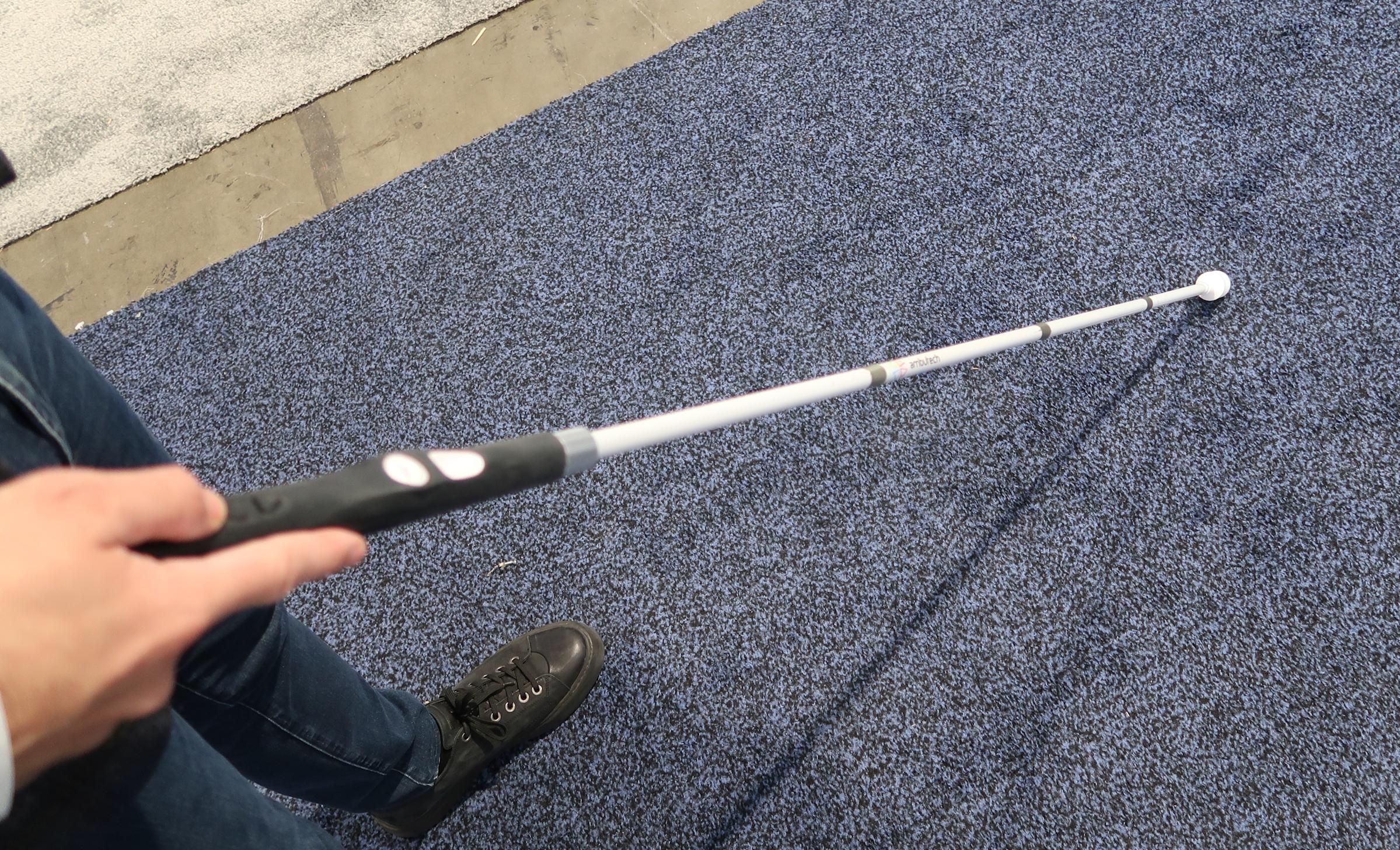 A person uses the Wewalk Smart Cane 2 to find their way through a CES booth. 