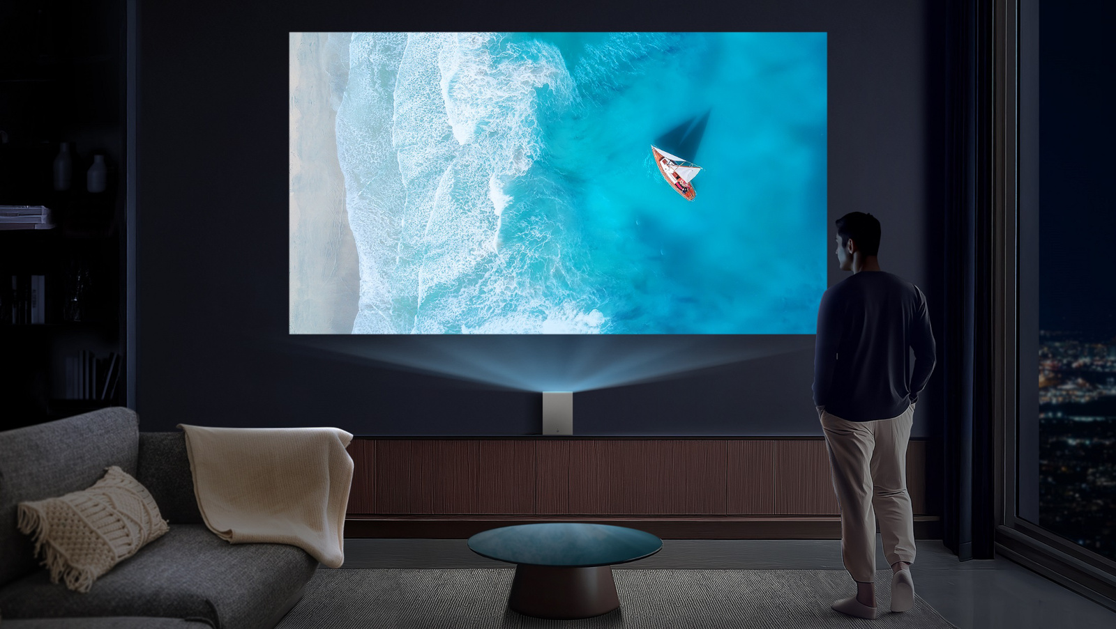 A person standing in front of a projected image of the beach on the wall. 