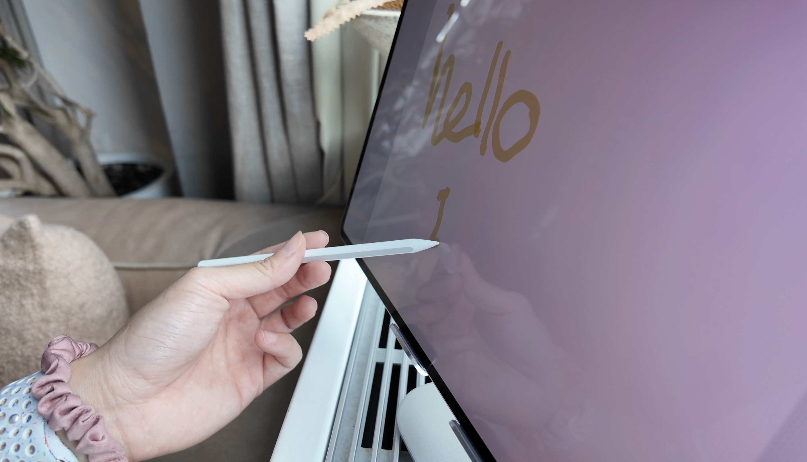 A close-up shot of the redesigned S Pen being held by a hand that is using it to write something on the Samsung Galaxy Tab S11 Ultra.