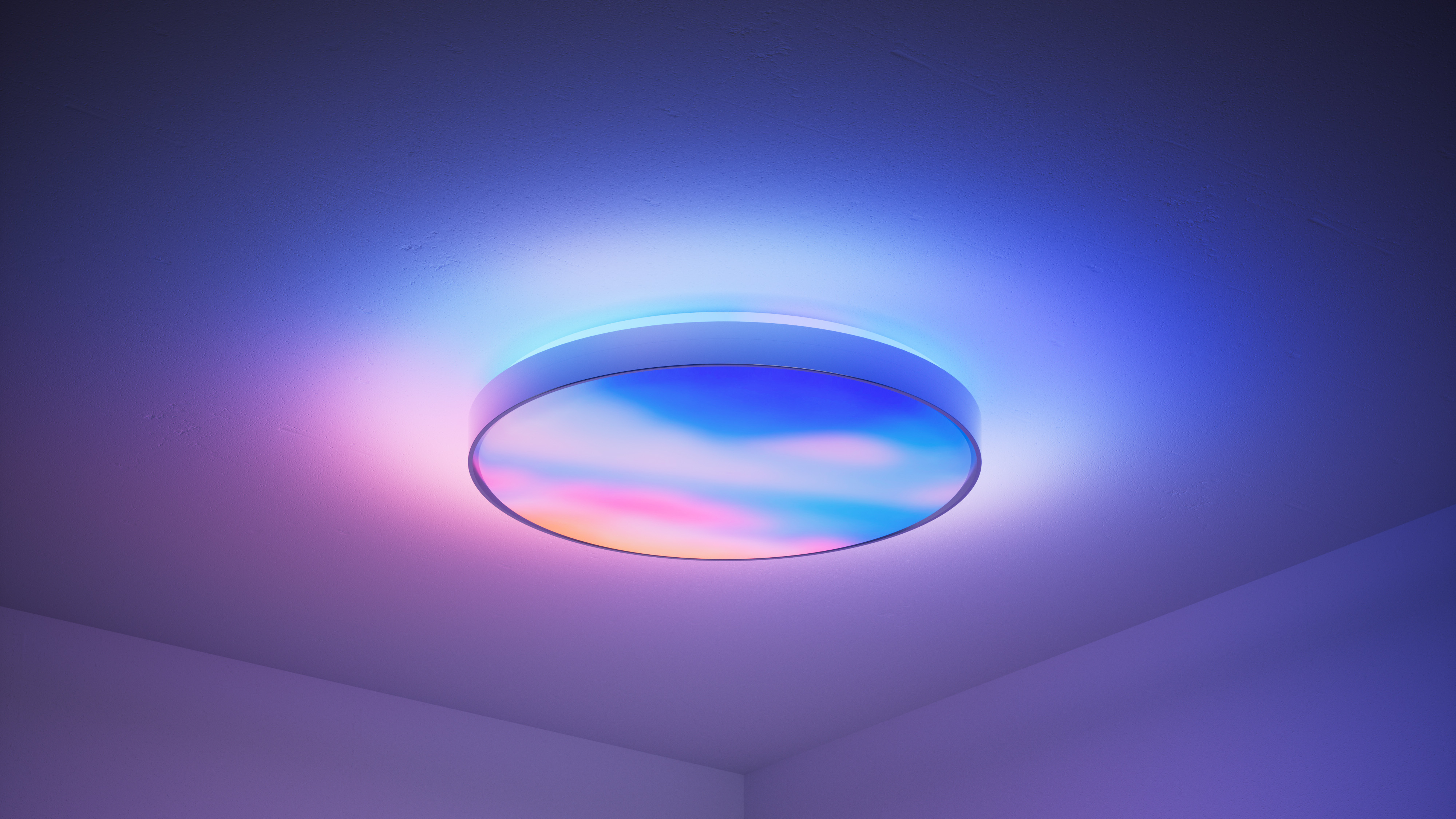 Product marketing photo. A ceiling light with a complex aurora-style gradient of colors.