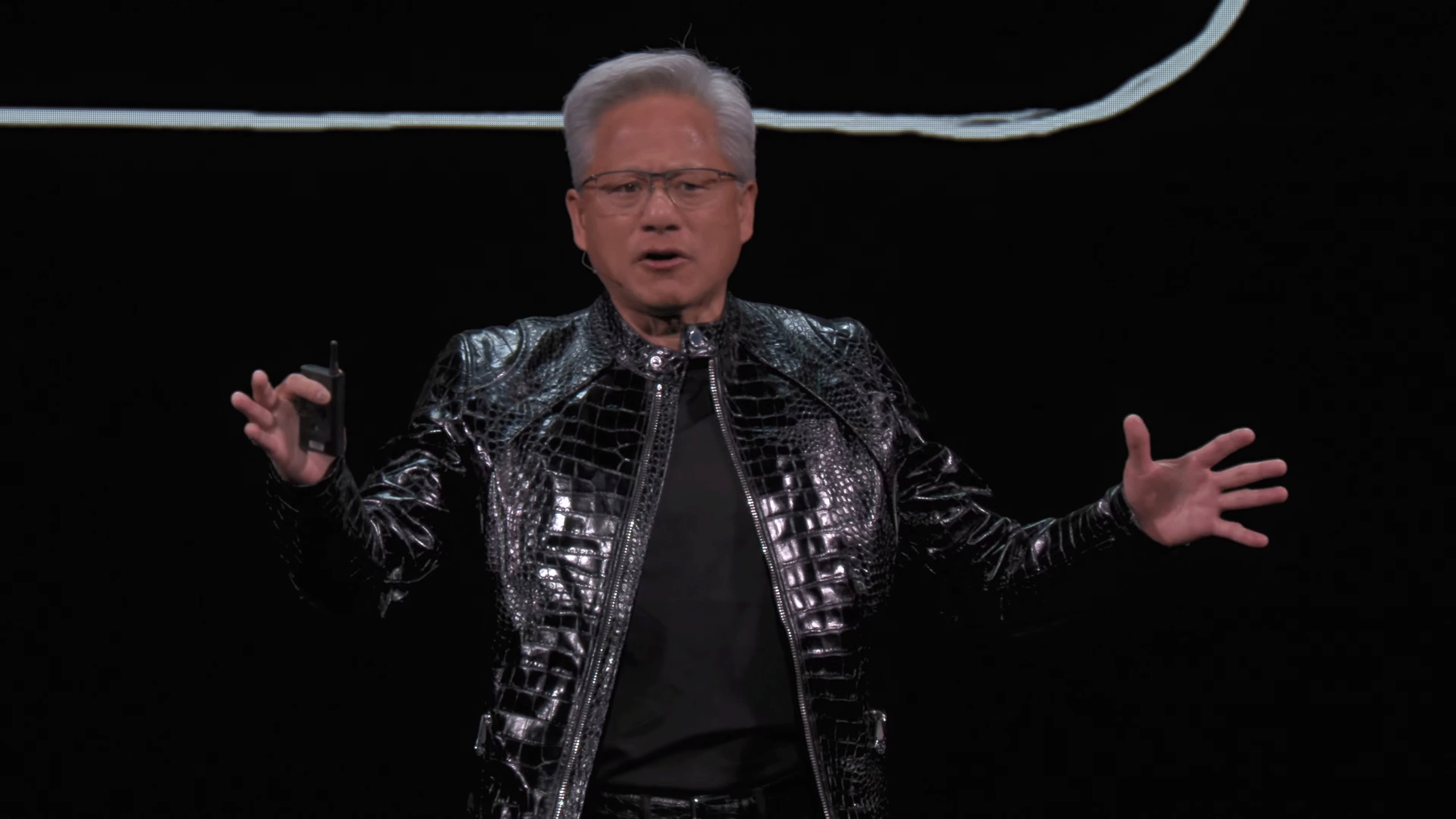 NVIDIA CEO Jensen Huang presents at CES 2026, wearing a black snakeskin-like jacket.