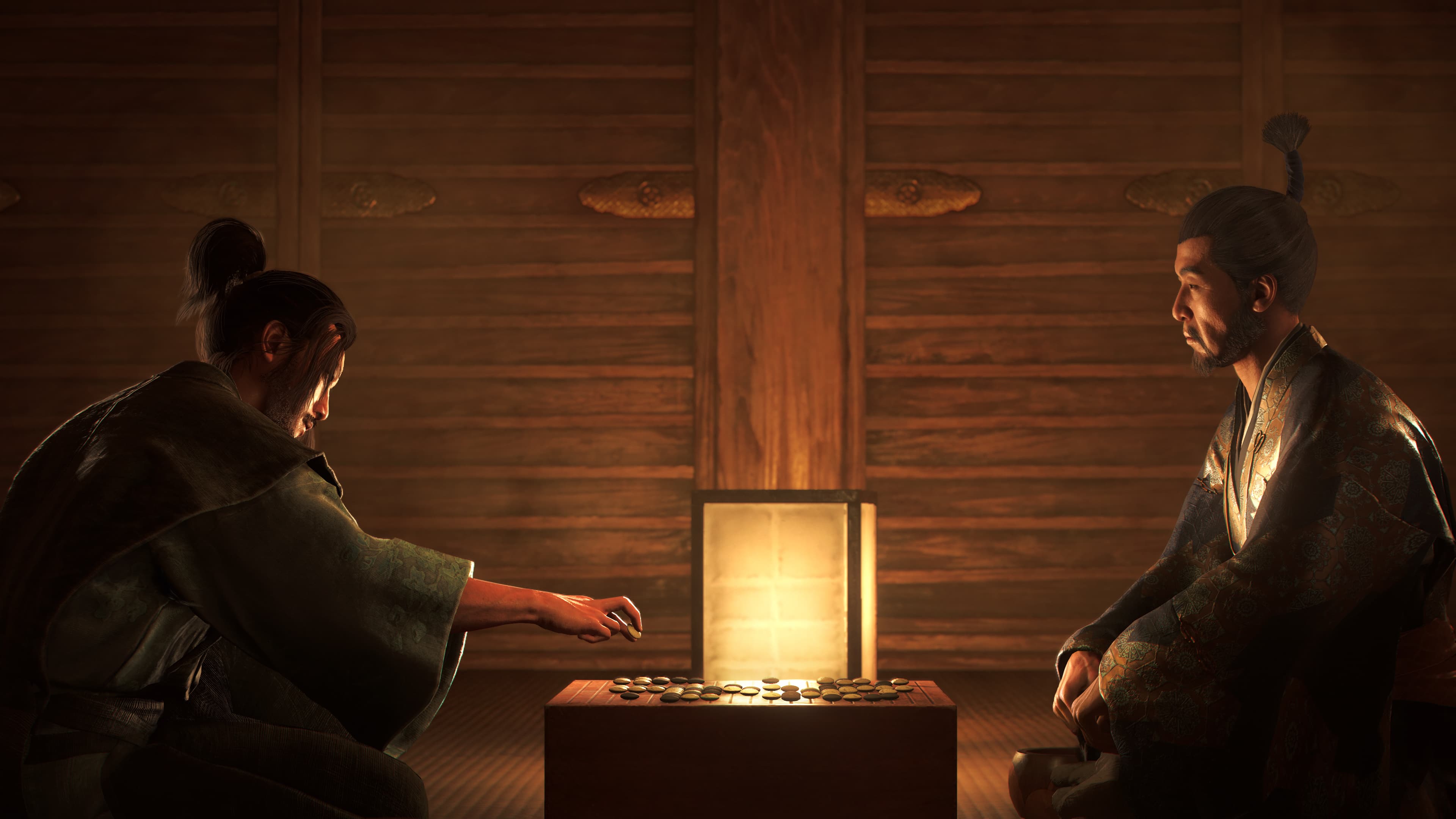 Two men backlit by a lantern play a game of Go in Assassin's Creed Shadows.