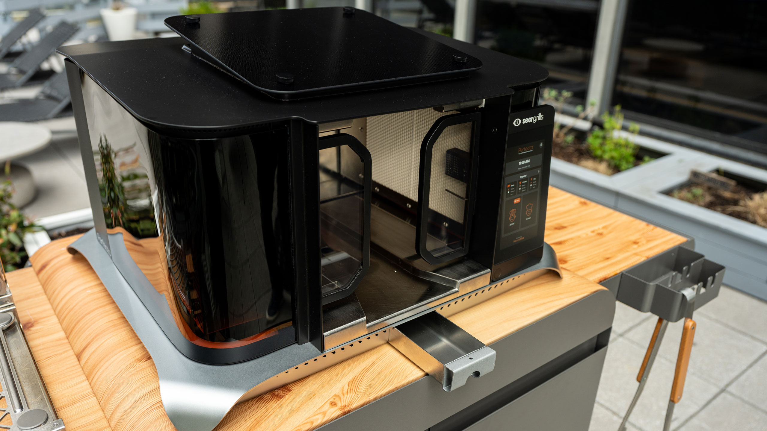 The Perfecta has a vertical cooking configuration with infrared burners that move automatically during use.